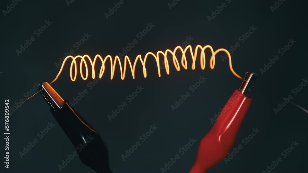 Video „Nichrome filament connected to power wires is heated to red