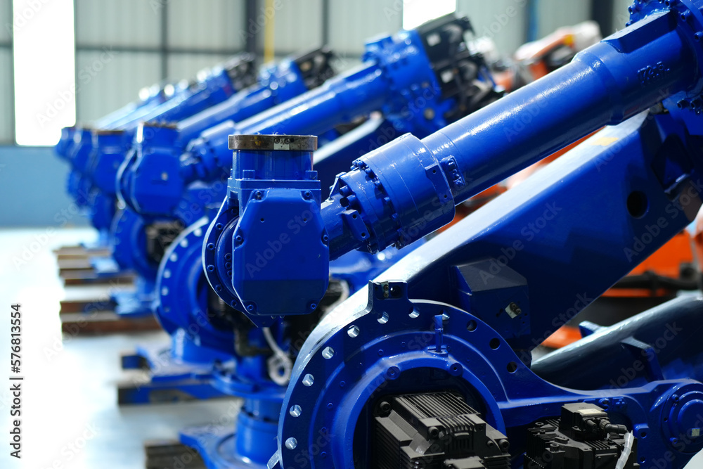 Fototapeta premium Robotic arm in futuristic assembly manufacturing factory, in factory shop floor.