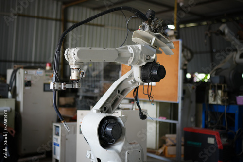 Robotic arm in futuristic assembly manufacturing factory, in factory shop floor.