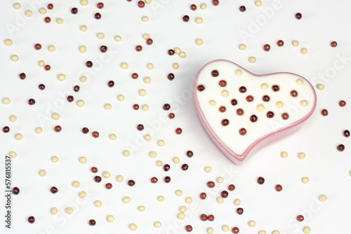 dessert yogurt with chocolate balls in a heart-shaped bowl. View of the beast flat lying with a copy of space