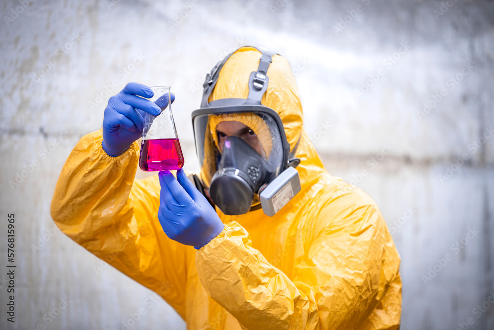 Obraz premium Chemical testing laboratory. Worker in special equipment and gas mask testing quality.