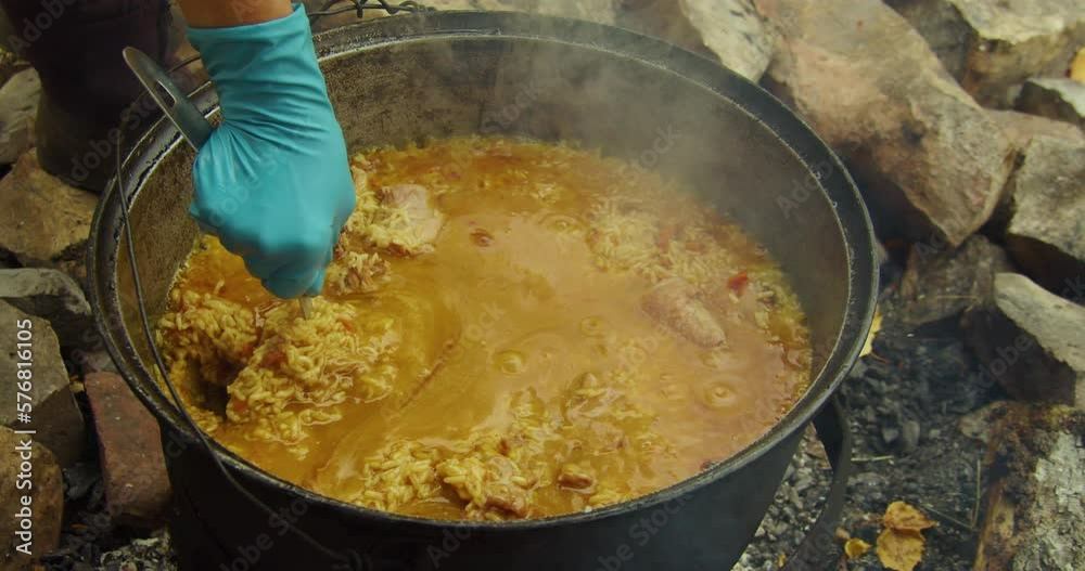 Cooking pilaf on an open fire in a cauldron. Cooking pilaf on an open fire in a cauldron.