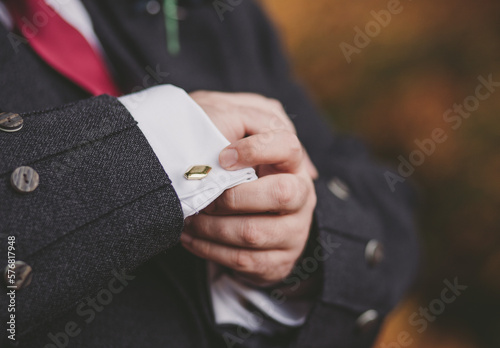 Man or groom buttons up his cufflinks close up