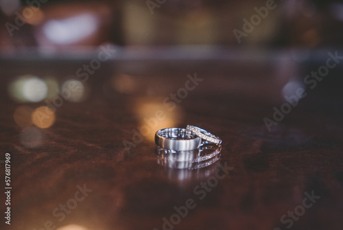 Two silver wedding rings isolated on a wooden shiny table with negative space