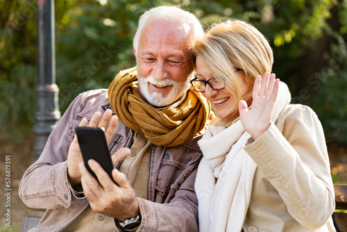Photography Cheerful elderly couple using banking apps on a smartphone to make payments outd
