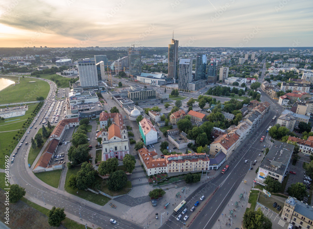 Vilnius Cityscape with Business District. Sunset Sky. Church of St. Archangel Raphael in Foreground