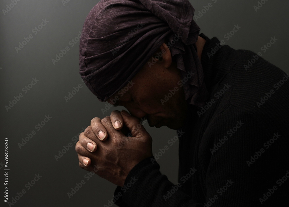 praying to god with hands together Caribbean man praying with black background stock photo praying to god with hands together Caribbean man praying with black background stock photo