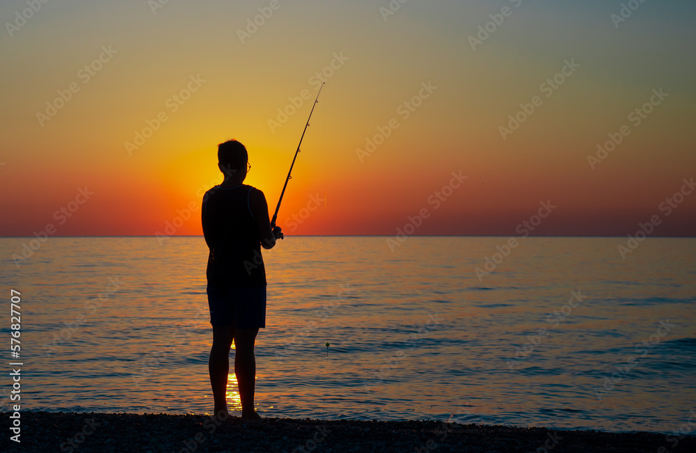 Ragazzo pescatore all alba, in riva al mare