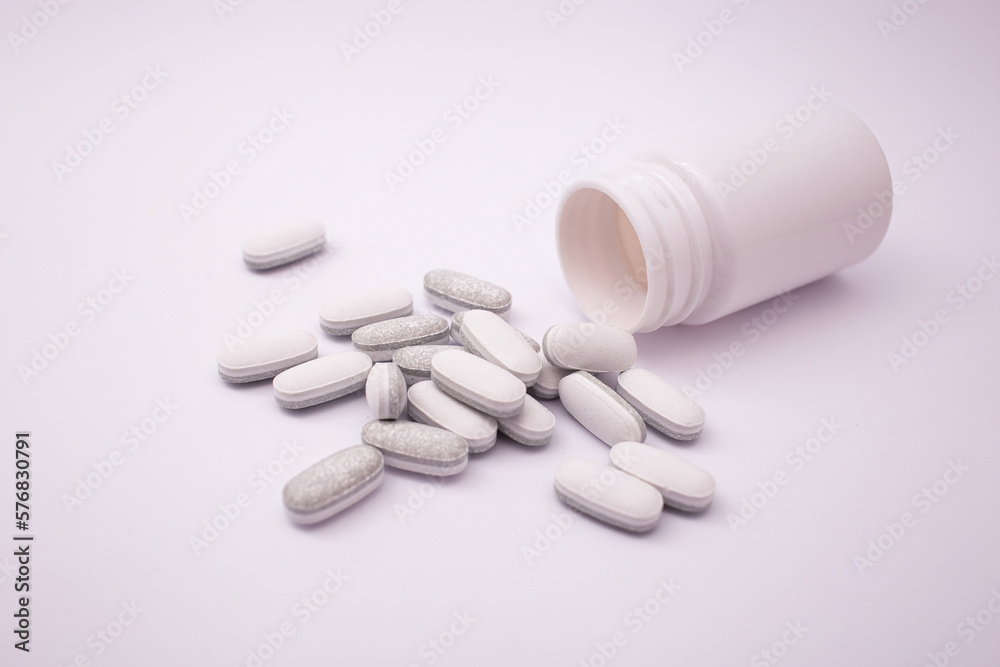 Pills in white and grey on a white background with a purple tint Pills in white and grey on a white background with a purple tint