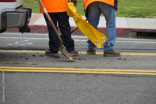 фотографія road crew fixing a pothole in the street