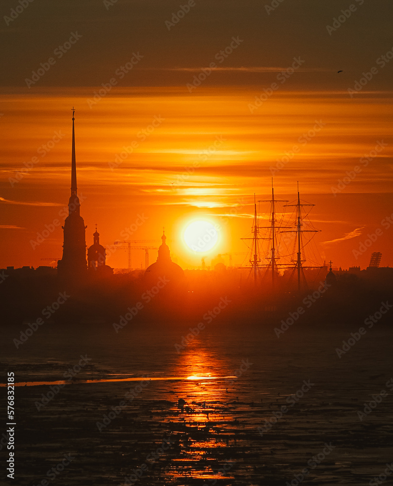Sunset over the Peter and Paul Fortress in St. Petersburg, Russia. Sunset over the city on the coast. Beautiful orange sunset over the river, the silhouette of the city at sunrise over the river. 