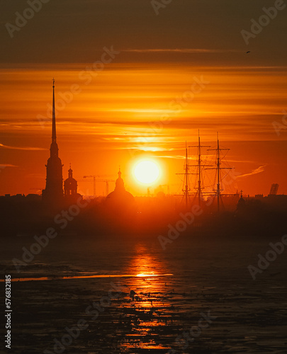Sunset over the Peter and Paul Fortress in St. Petersburg, Russia. Sunset over the city on the coast. Beautiful orange sunset over the river, the silhouette of the city at sunrise over the river.  © Dmitry Presnyakov