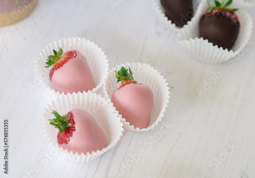 Принти на полотні Pink chocolate covered or dipped strawberries in paper cases on a white backgrou
