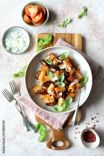 Pasta alla norma - Italian pasta with eggplant, tomato sauce and parmesan cheese. Top view.