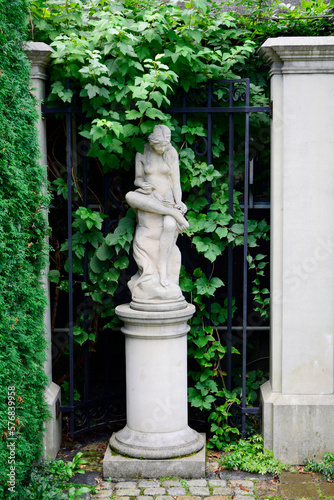 posąg kobiety w ogrodzie, posąg kobiety z piaskowca otoczony pnączami, statue of a woman in garden, garden statue of a woman surrounded by green climber