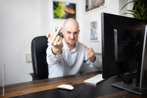 Angry employee shows middle finger in his office/home office after meeting for pitch and continues to make obscene gestures