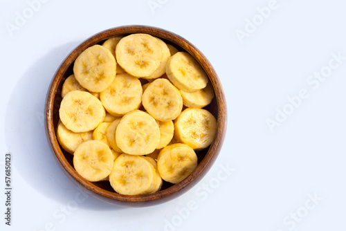 Banana slices in wooden bowl on white background