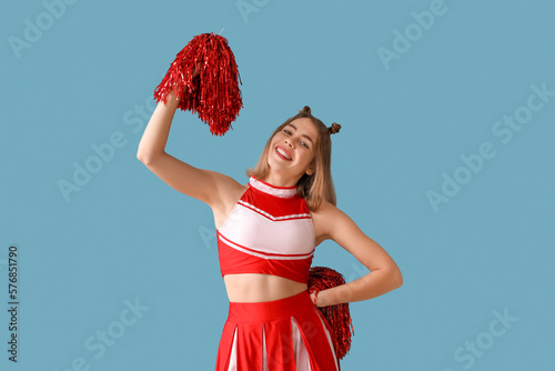 Beautiful cheerleader on blue background