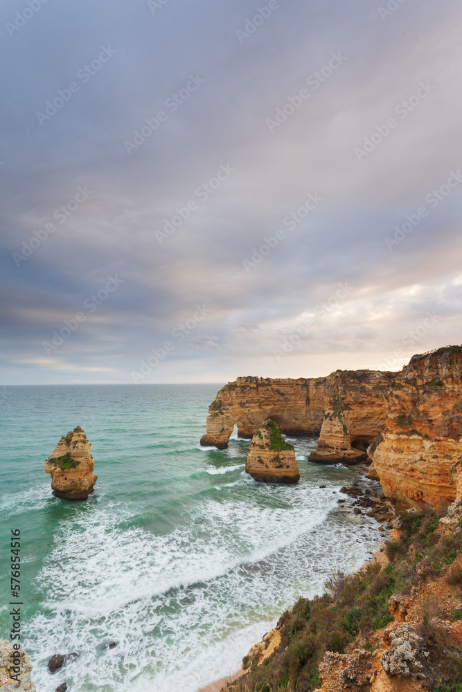 Landscape on the Algarve coast at sunset. Beach in southern Portugal the best travel destination for tourists on vacation. seascape with caves through the cliffs