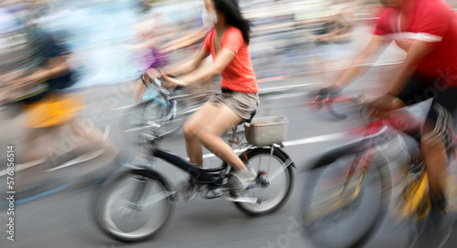 Blurred silhouettes of cyclists on a city street