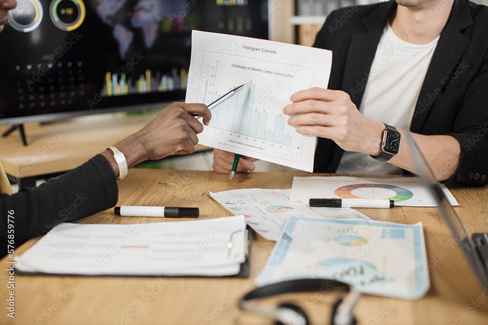 Focused african and caucasian men hands having paperwork at office. Close up view of male hands managers with documents in desk analysing financial report. People, business and technology concept.