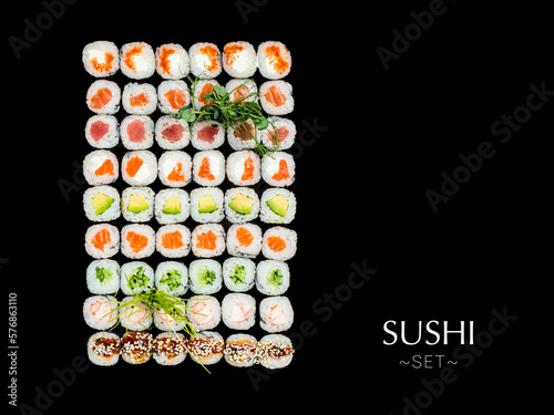 Many Japanese Maki sushi roll pieces isolated on black background. Large set with salmon  tuna  shrimp  avocado  cucumber with micro greens on top. Ready banner concept with text  copy space