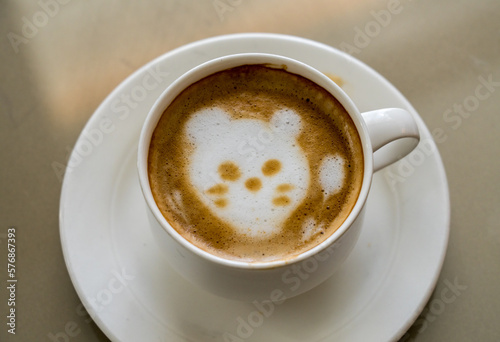 Shape of a cat or kittens face drawn in the milk foam or froth in top of cup of coffee