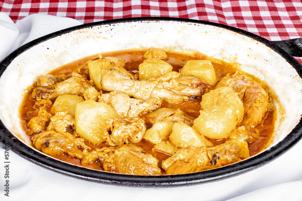 homemade chicken stew with tomato, onion and potato on checkered tablecloth. homemade chicken stew with tomato, onion and potato on checkered tablecloth.
