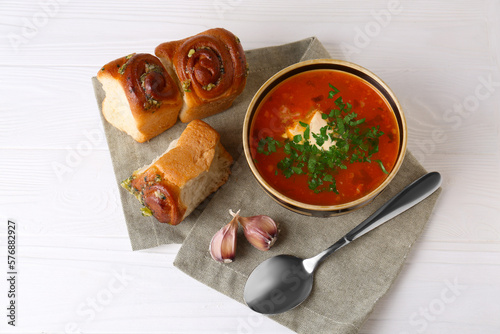 Delicious borsch served with pampushky on white wooden table, above view. Traditional Ukrainian cuisine