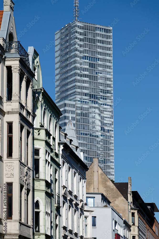 beautiful old buildings from the end of the 19th century in the belgian quarter of cologne in front of the modern skyscraper kölnturm in the background