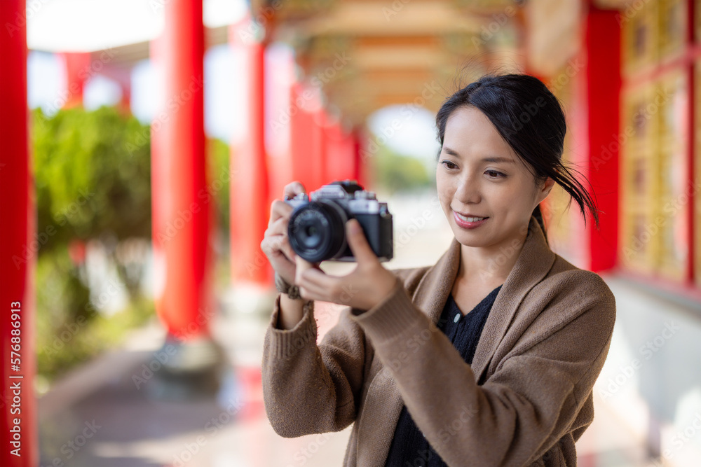 Travel woman use digital camera to take photo in Chinese temple