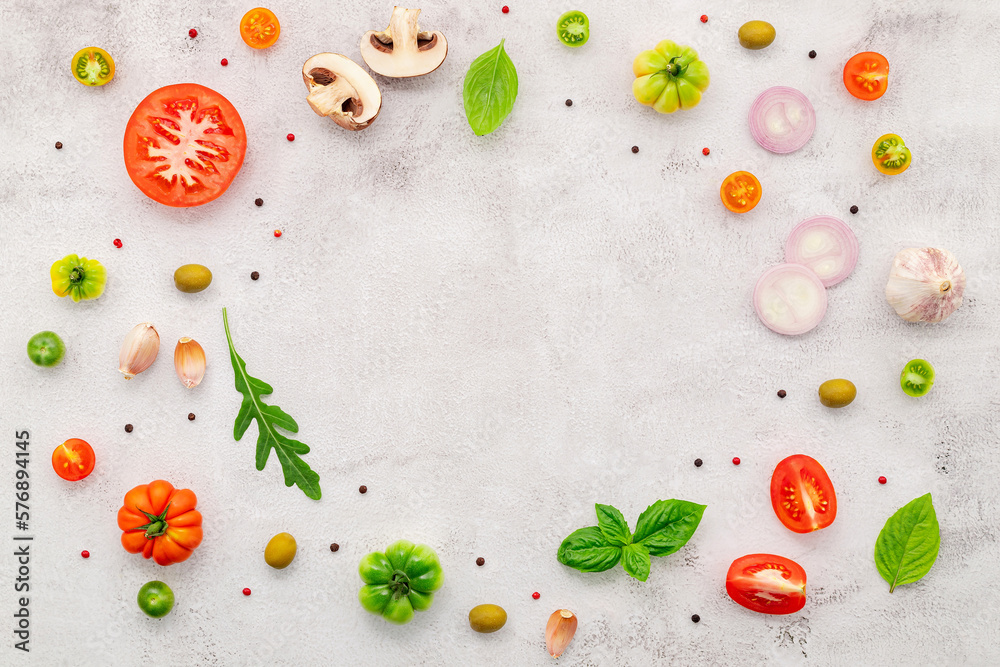 The ingredients for homemade pizza set up on white concrete background.
