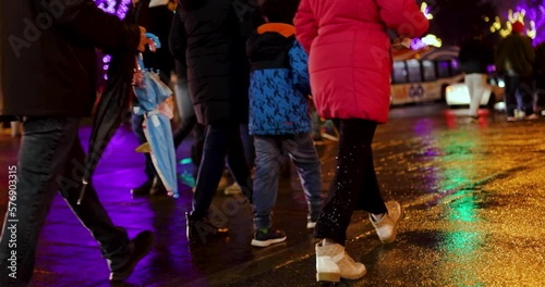 People crossing wet street at night with bright lights and charisms and new year decorations, footpath,
Niagara Falls Canada