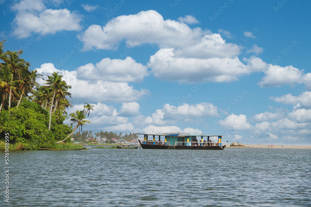 Traditional houseboat of Kerala cruising by the Golden sand Beach.
