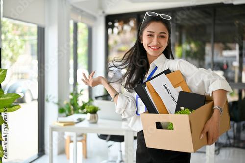 Smiling Asian female office worker, celebrating her resignation, happy to quit her job. photo