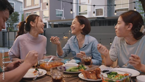 Mom enjoy thai meal cooking for family day meet talk home dining at dine table cozy patio. Group asia people young adult man woman friend fun joy relax warm night time picnic eat yummy food with mum.