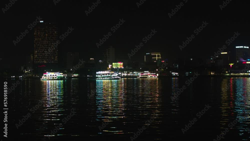 Cruise lit with colorful lights sailing across Han river in Da Nang city, Vietnam, Wide angle shot Cruise lit with colorful lights sailing across Han river in Da Nang city, Vietnam, Wide angle shot