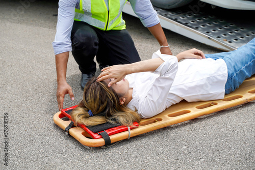 Closeup ambulance and rescue workers helping woman driver from car accident on road.