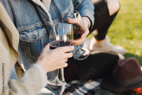 Cropped photo of two glasses with wine in hands of romantic couple