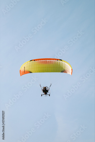 A person paragliding in a sky on a clear day