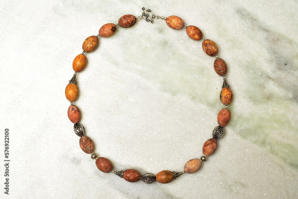 Top view of brown semi precious stone beads necklace on floor Top view of brown semi precious stone beads necklace on floor