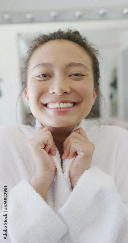 Vertical video of portrait of happy asian woman smiling in bathroom, in slow motion Vertical video of portrait of happy asian woman smiling in bathroom, in slow motion