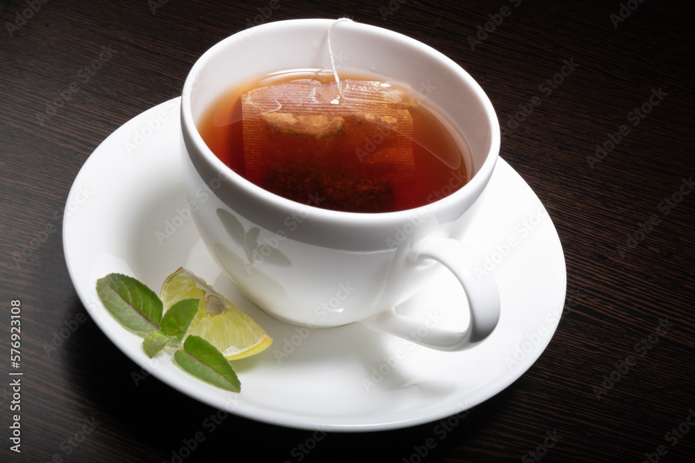 Lemon tea cup with slice of lemon and mint leaf Lemon tea cup with slice of lemon and mint leaf