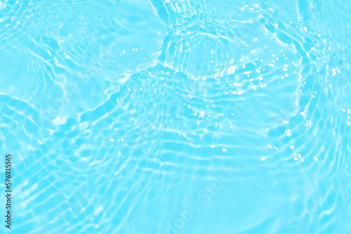 Fototapeta Naklejka Na Ścianę i Meble -  Defocus blurred transparent blue colored clear calm water surface texture with splashes and bubbles. Trendy abstract nature background. Water waves in sunlight with copy space. Blue watercolor shining