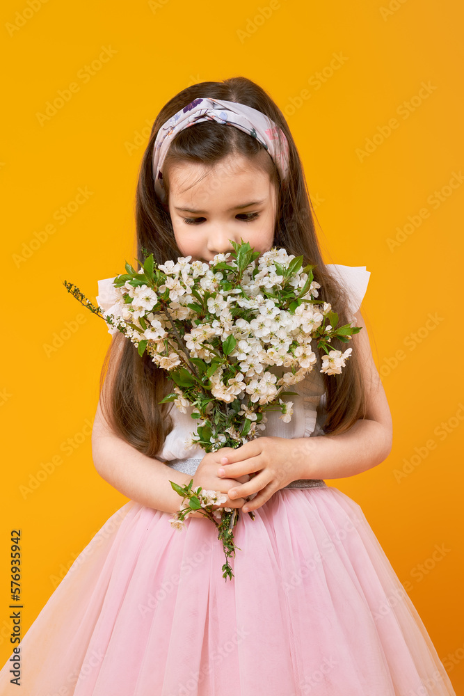 Cute little girl sniffing the bouquet of spring flowers Cute little girl sniffing the bouquet of spring flowers