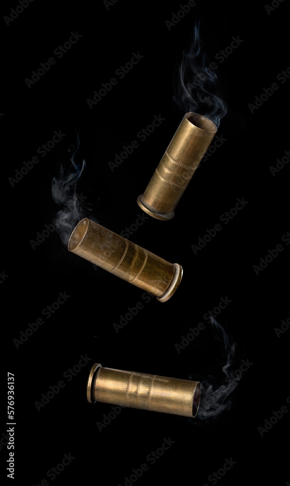Casing fired with with smoke out of a handgun falling on black background