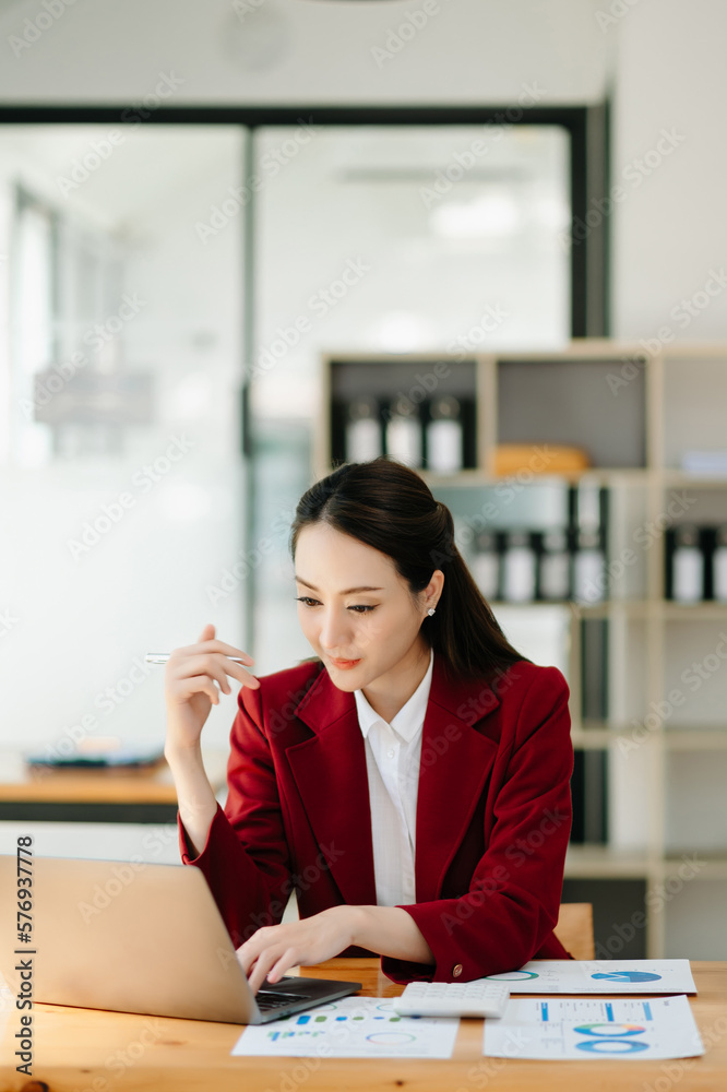 Young beautiful woman using laptop and tablet while sitting at her working place. Concentrated at work... Young beautiful woman using laptop and tablet while sitting at her working place. Concentrated at work...