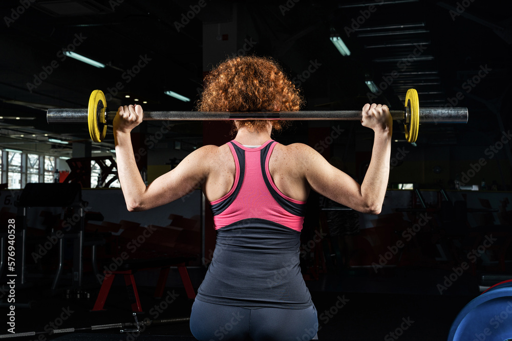 Woman bodybuilder engaged with a barbell in the gym Woman bodybuilder engaged with a barbell in the gym
