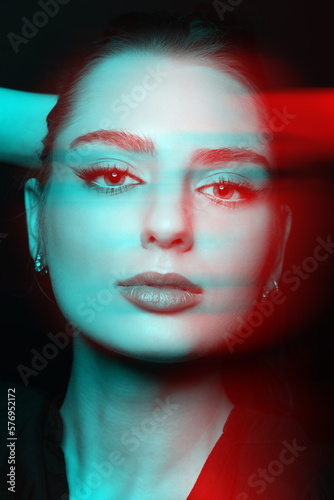 Beautiful woman with make-up close-up studio portrait in RGB color split effect style. Model looking at camera with seductive eyes and holding one hand behind head. Futuristic looking style
