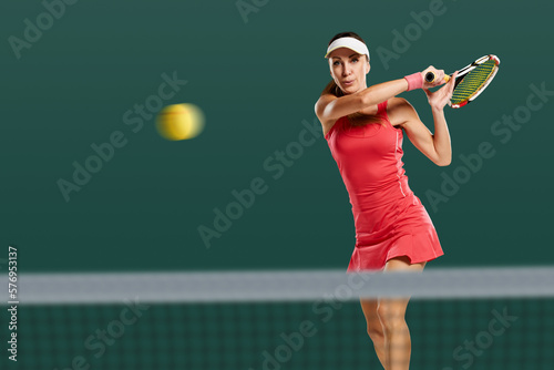 Young attractive sporty woman playing tennis and beating ball with racket © Denys Kurbatov
